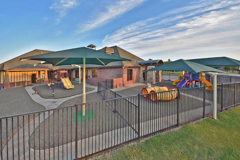 Large playground outside a red brick building.