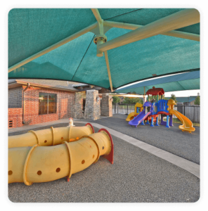 Childrens playground under a large green tent.